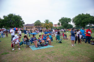 Crowd sitting in lawn chairs, listening to music