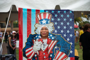 Smiling woman getting her picture taken with Uncle Sam photo booth