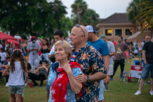 Woman and man in crowd, listening to music