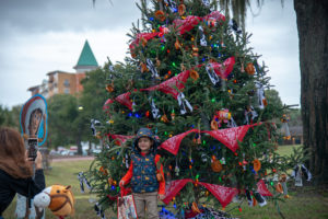 Little girl standing in front of christmas tree