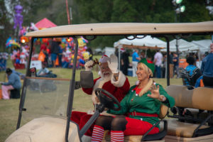 Santa and elf riding in gold cart